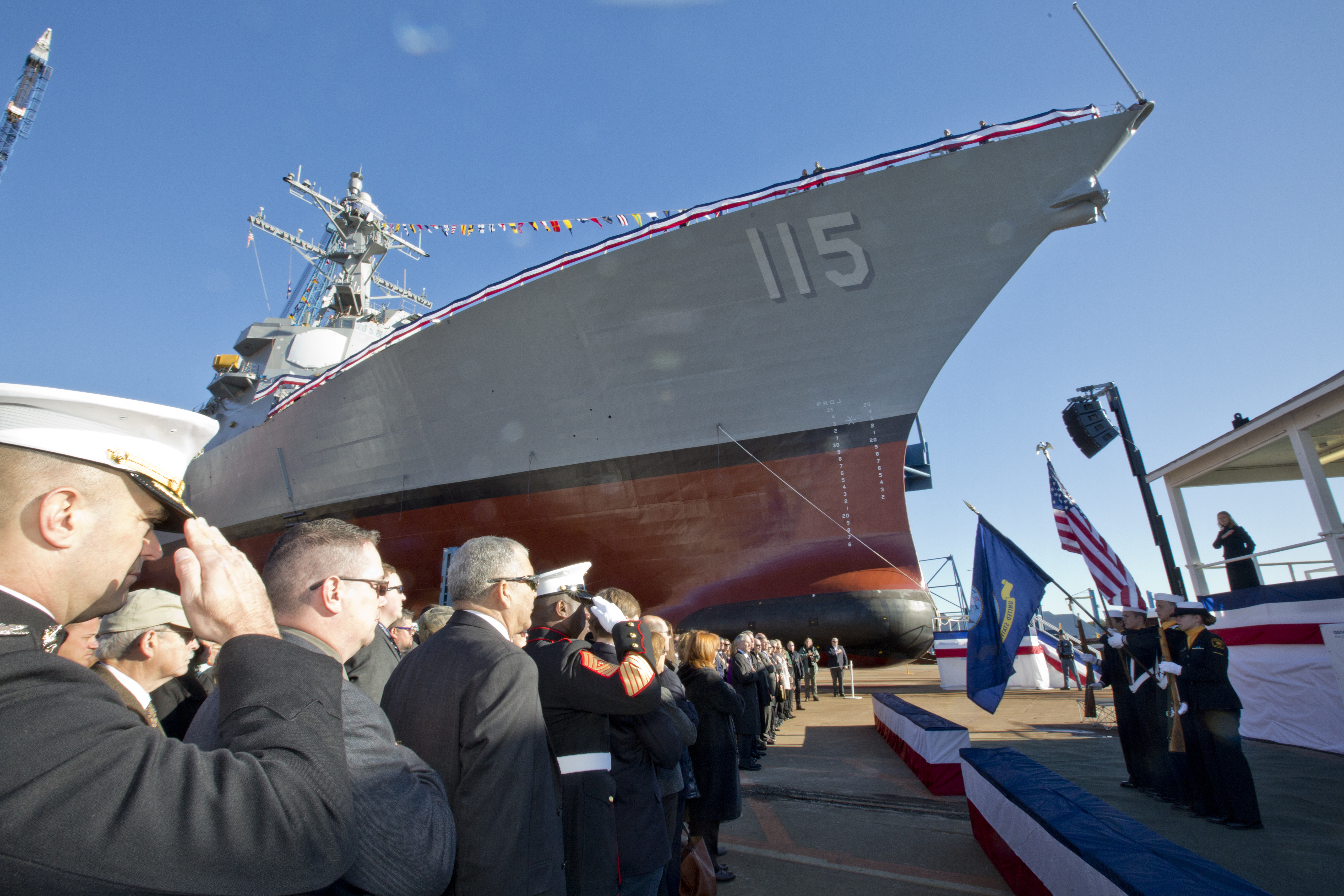 U.S. Marines, Sailors, and guests honor the American and Navy flag during the USS Rafael Peralta christening ceremony at General Dynamics Bath Iron Works, Bath, Maine, Oct. 31, 2015. US Navy Photo