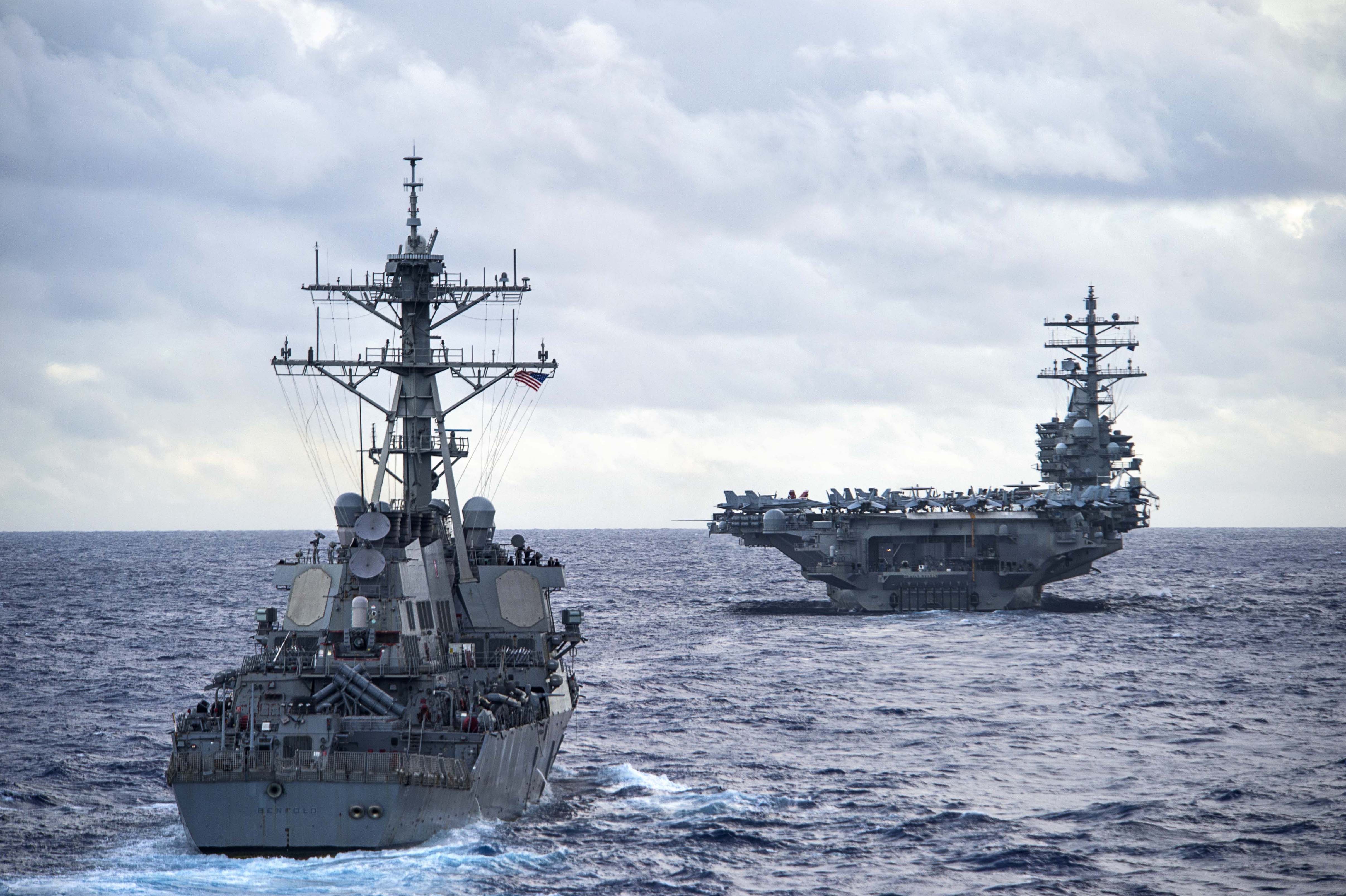 Arleigh Burke-class guided-missile destroyer USS Benfold (DDG-65), left, and the Nimitz-class Aircraft carrier USS Ronald Reagan (CVN-76) transit the Philippine Sea on Sept. 23, 2016. US Navy Photo
