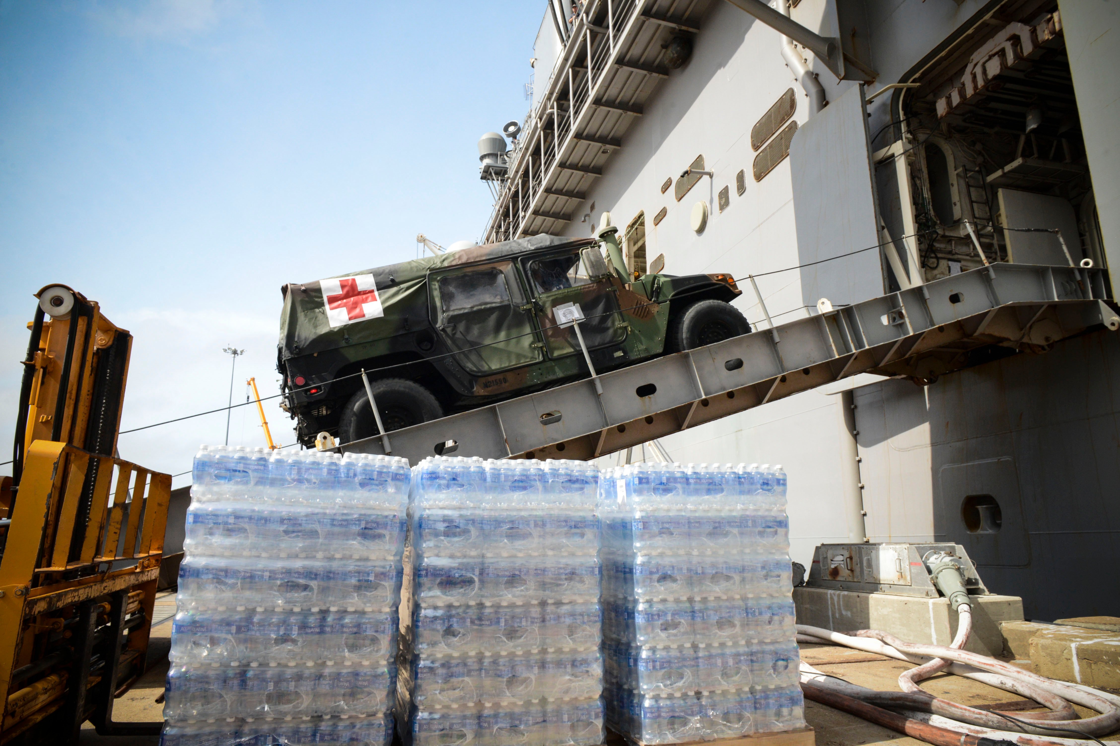 A medical vehicle attached to the 24th Marine Expeditionary Unit (24th MEU), drives aboard the amphibious assault ship USS Iwo Jima (LHD 7) during an Oct. 7 onload of more than 500 Marines from the 24th Marine Expeditionary Unit and nearly 300 pallets of supplies. US Navy photo.
