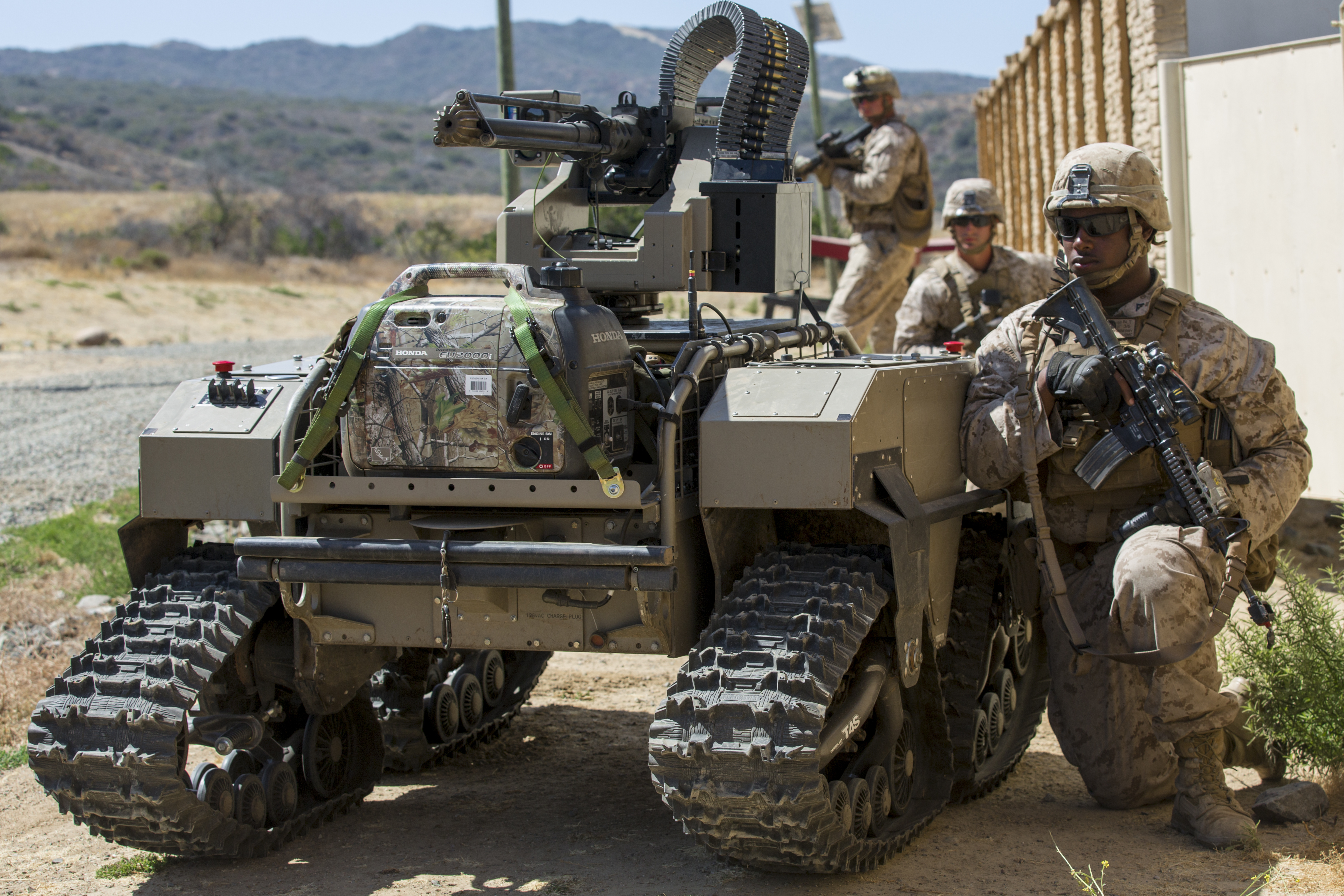 U.S. Marine Lance Cpl. Deonce Cushinberry, a rifleman with Kilo Company, 3rd Battalion, 5th Marines Regiment, takes cover from simulated enemies behind a Weaponized Multi-Utility Tactical Transport vehicle, a multifunction force multiplier configured to persist, protect and project the small unit, during an exercise for Marine Corps Warfighting Laboratory Marine Air-Ground Task Force Integrated Experiment on Camp Pendleton, Calif., July 13, 2016. US Marine Corps photo.