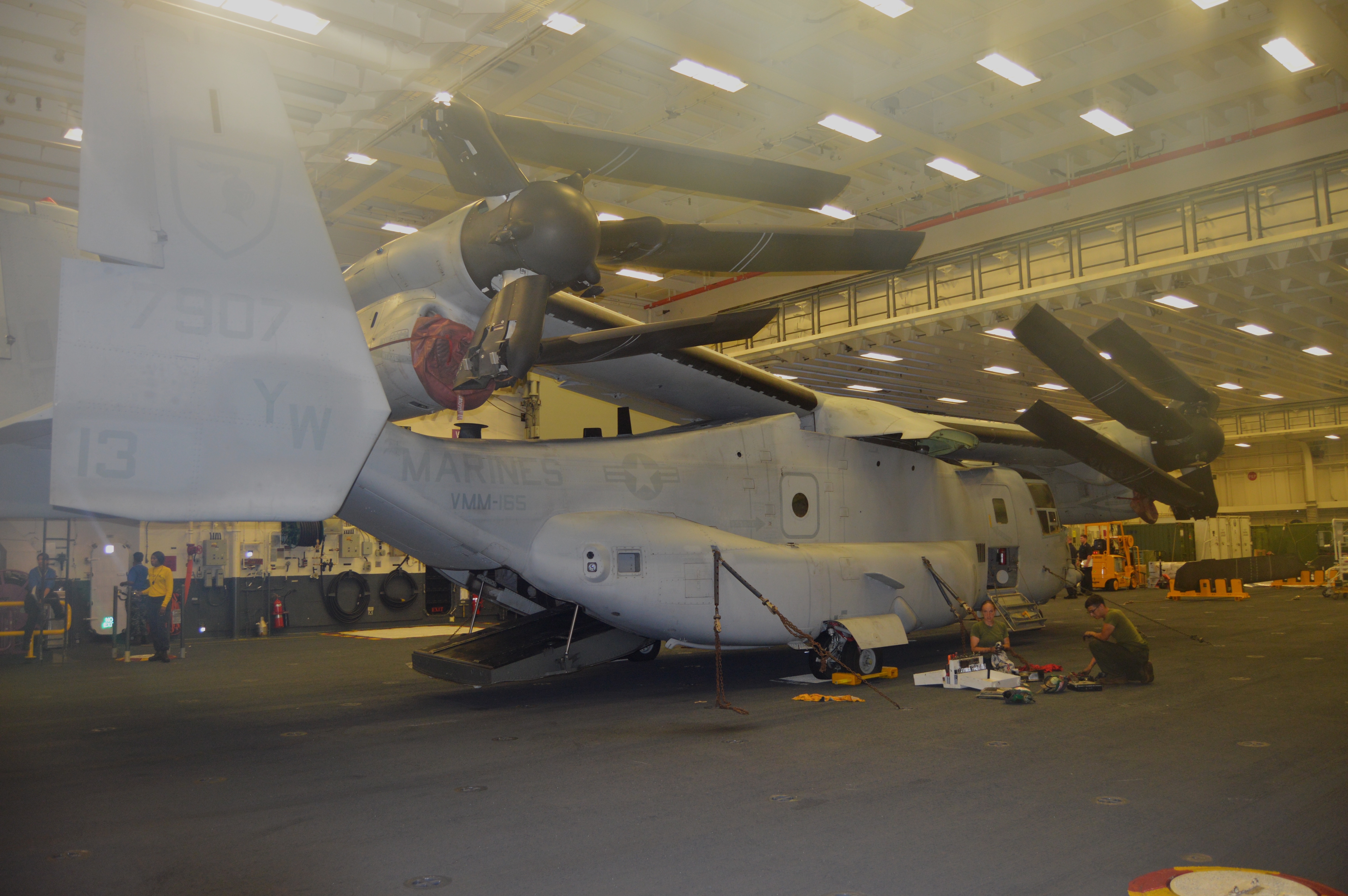 Marines with VMM-165 work on an MV-22 Osprey during the Rim of the Pacific exercise in July 2016 in USS America's large aviation maintenance bay, designed specifically for the V-22 and the F-35B Joint Strike Fighter that are larger than the aircraft they replace. USNI News photo.