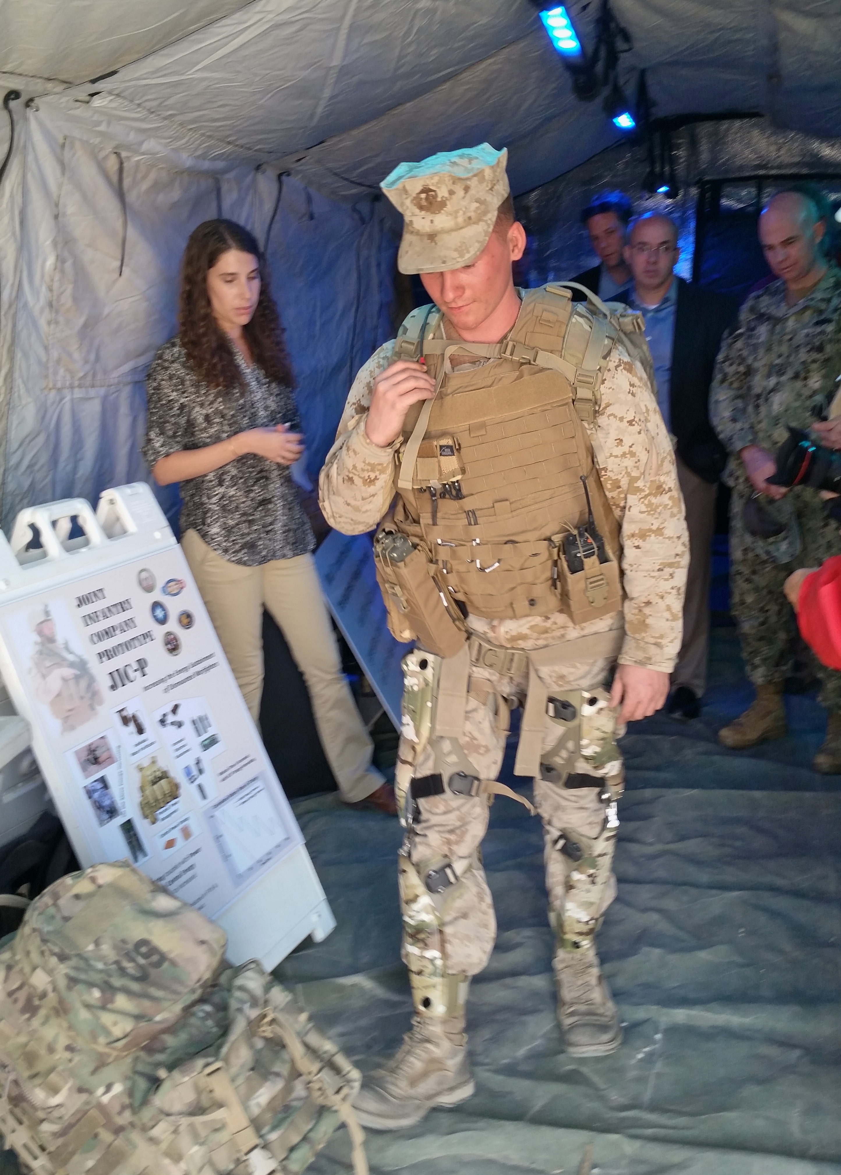 Lance Cpl. Corey Georski demonstrates the Joint Infantry Combat Prototype as Sara Lohmann, lead engineer at Naval Surface Warfare Center Dahlgren, explains how it produces energy that can power gear and recharge batteries whenever the Marine walks or runs. Gidget Fuentes Photo