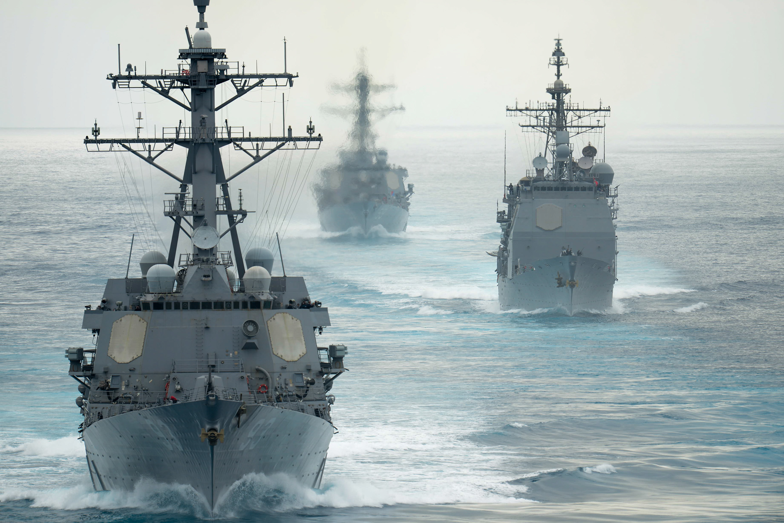 The guided-missile destroyers USS Russel (DDG 59), USS Chung Hoon (DDG 93) and the guided-missile cruiser USS Mobile Bay (CG 53) follow the aircraft carrier USS John C. Stennis (CVN 74) during a show of force transit on Aug. 11, 2015. US Navy photo.