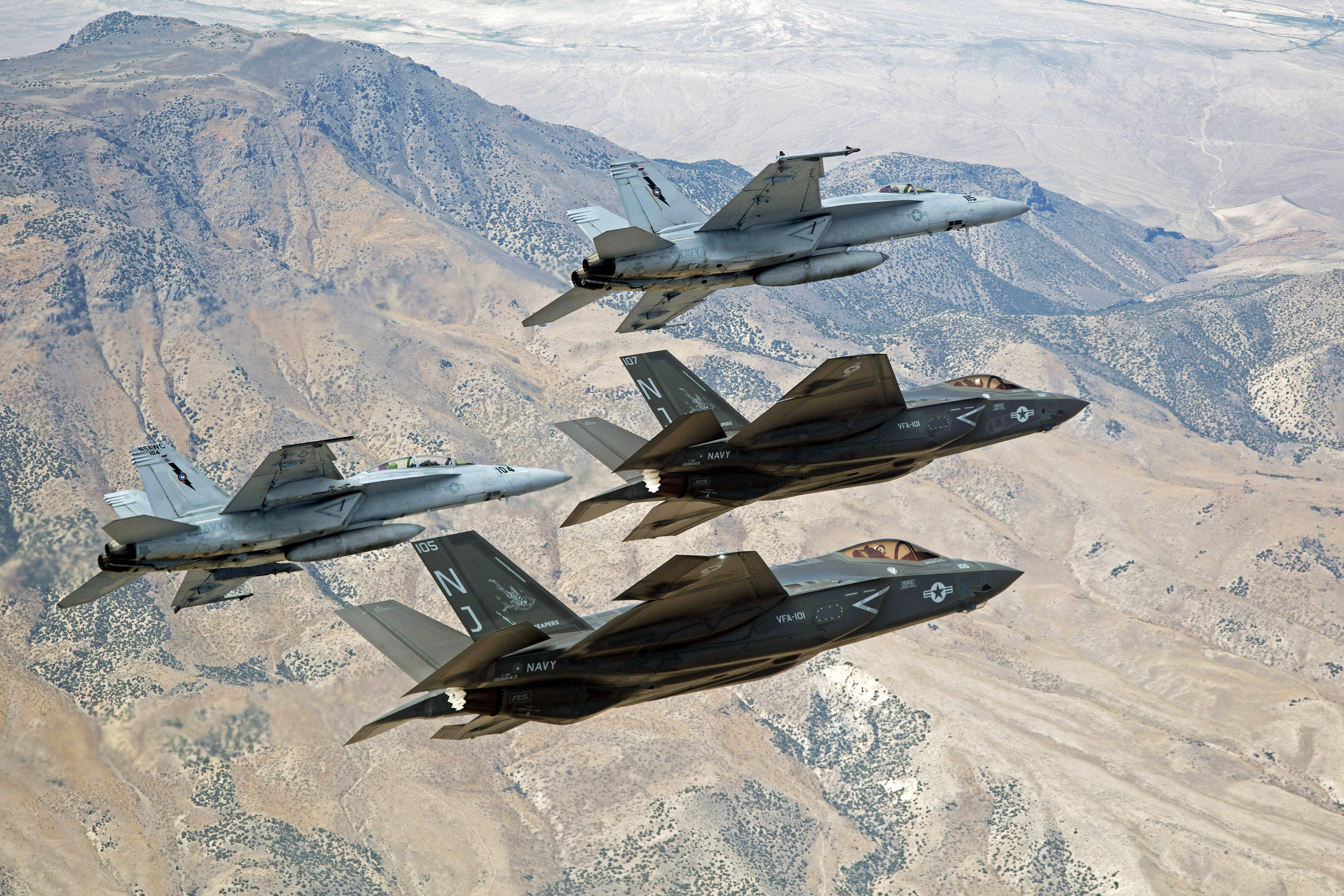 F-35C Lightning IIs, attached to the Grim Reapers of Strike Fighter Squadron (VFA) 101, and an F/A-18E/F Super Hornets attached to the Naval Aviation Warfighter Development Center (NAWDC) fly over Naval Air Station Fallon's (NASF) Range Training Complex in September 2015. US Navy photo.